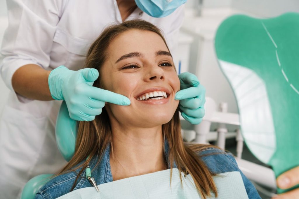 Kvinna som ler på besök för tandvård hos tandläkare i Klippan